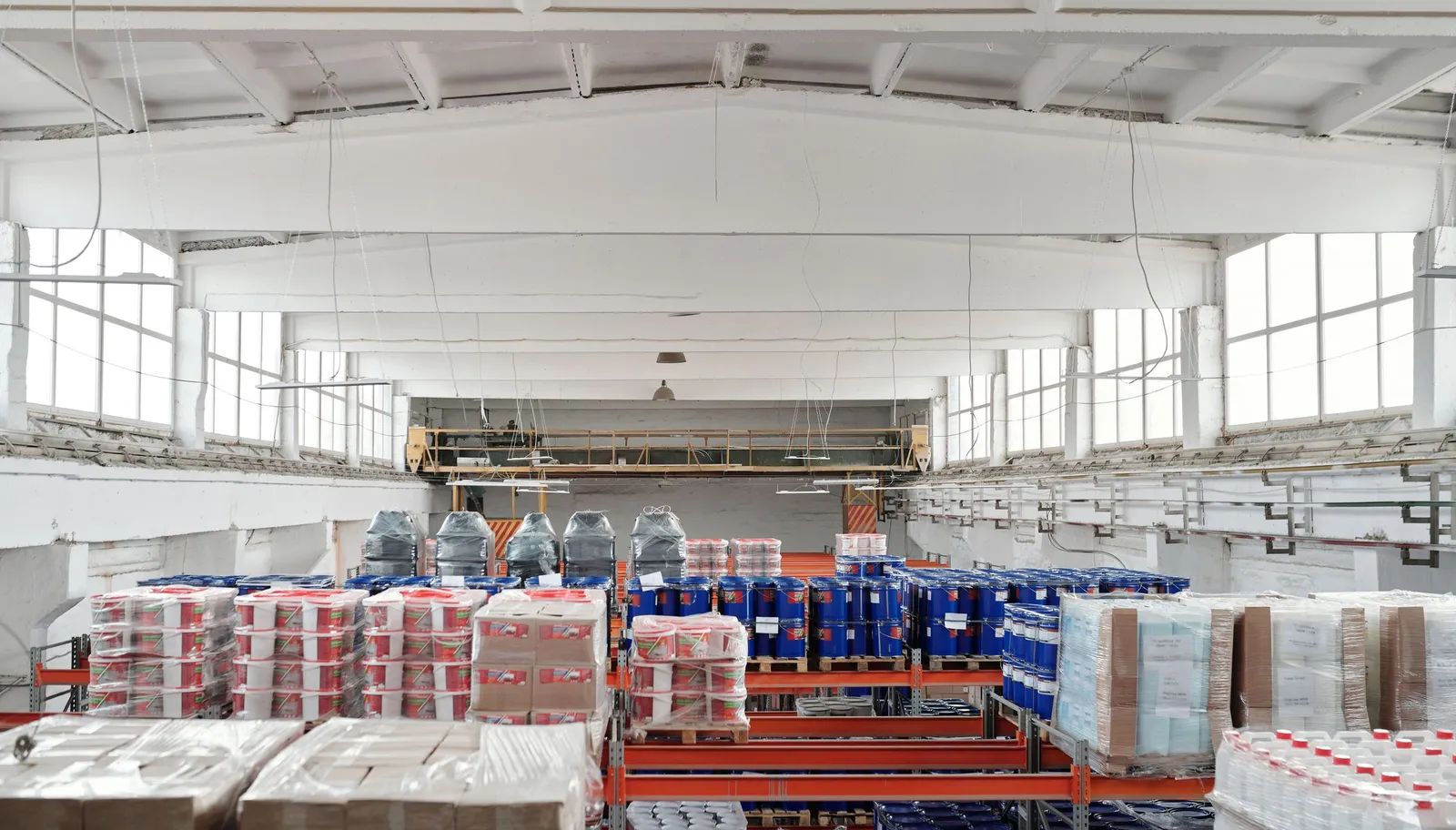 Warehouse racks holding stacked pallets of packaged consumer products