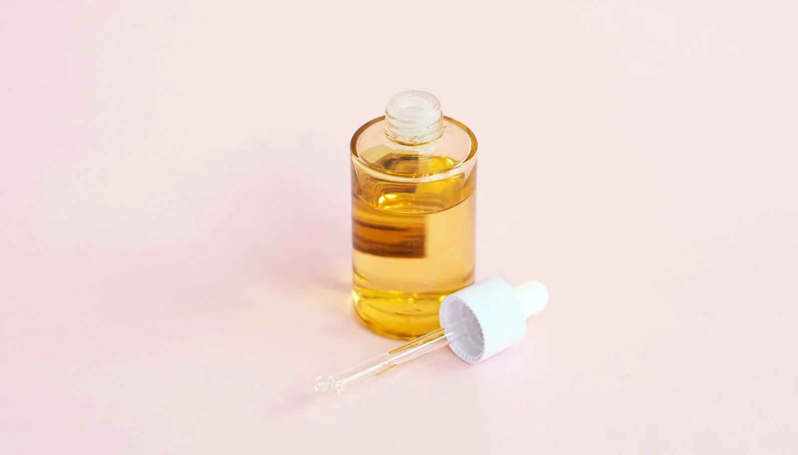 Blank glass serum bottle with dropper, the kind of package a spa line's label goes on.