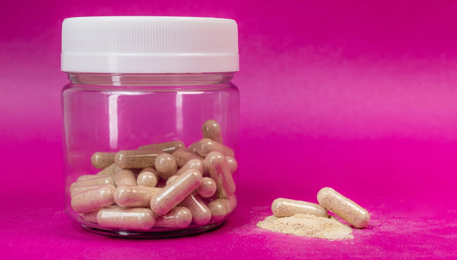 Supplement capsules beside loose powder, showing capsule and powder formats