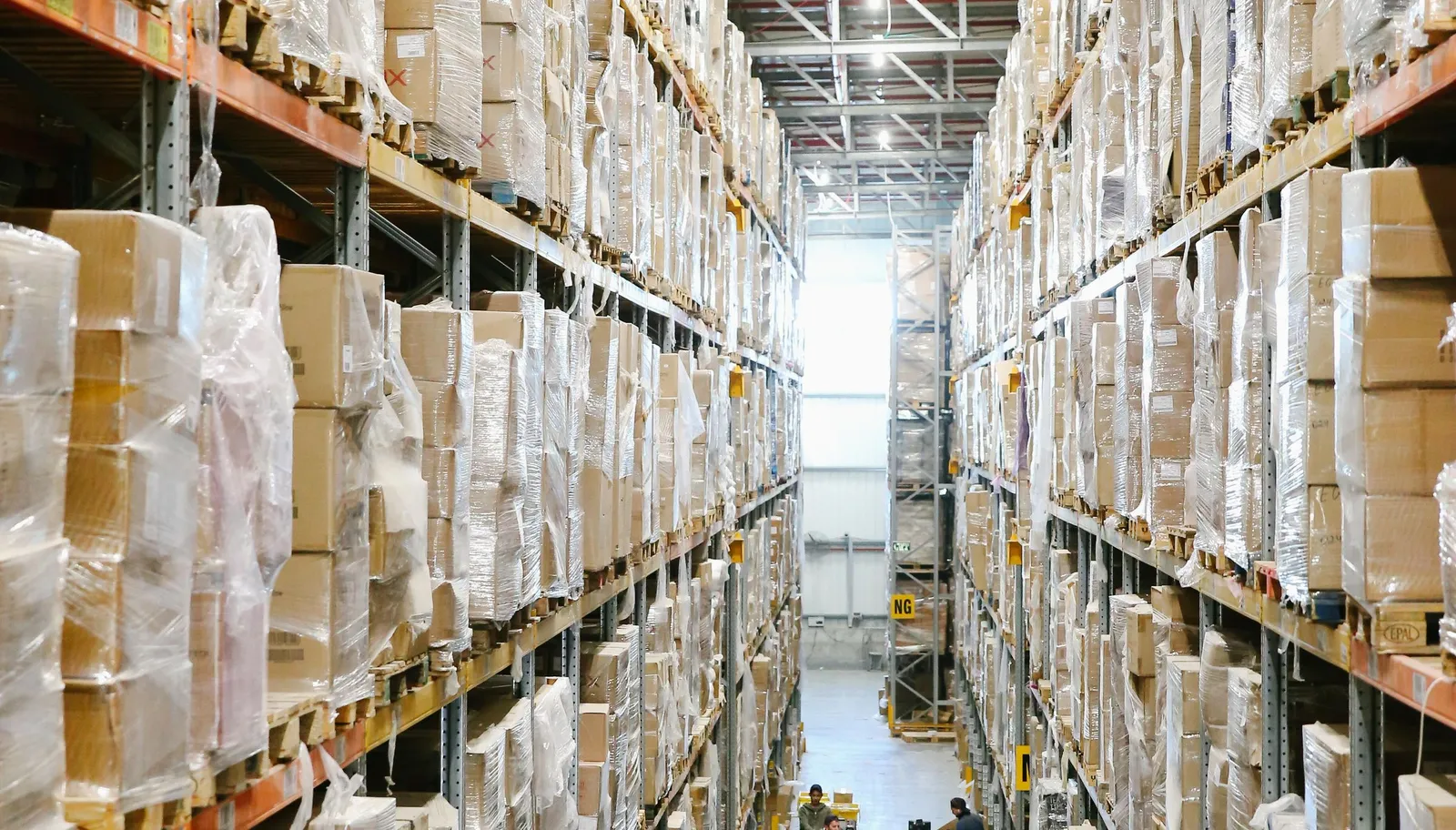 Warehouse aisle with shelves stacked with cardboard cases ready to ship to retail distribution centers