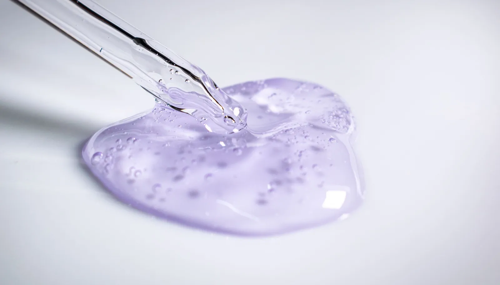 Pipette dispensing a clear gel during cosmetic formulation