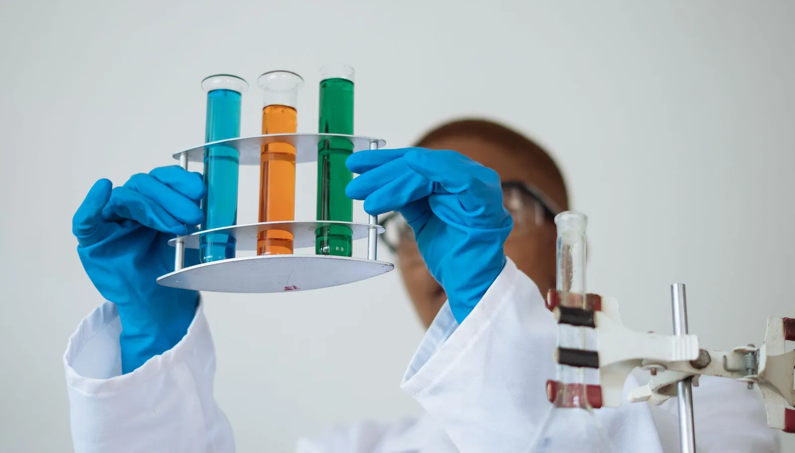 Gloved lab technician checking sample tubes during stability testing